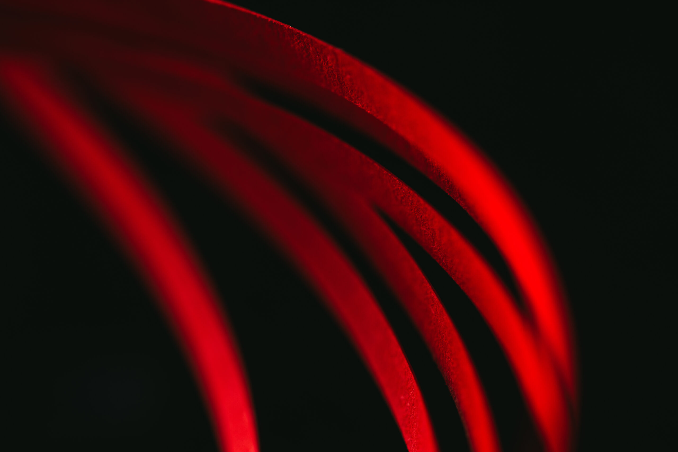 Abstract flowing red lines against a black background
